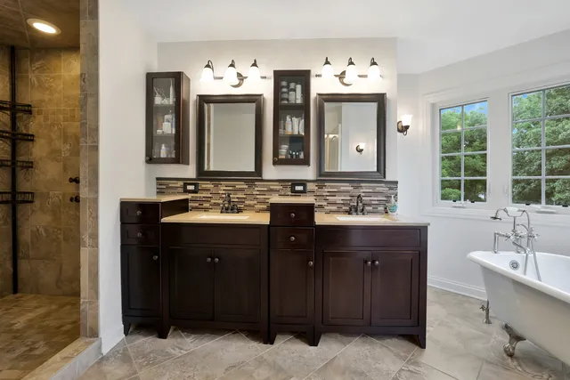 a bathroom with a double vanity sink and mirror with shower