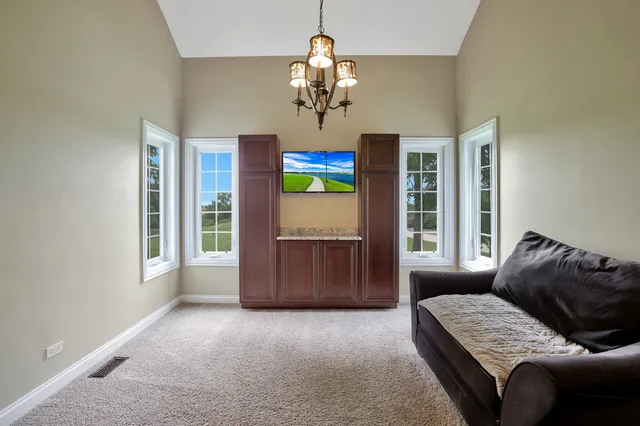 a living room with furniture chandelier and a window