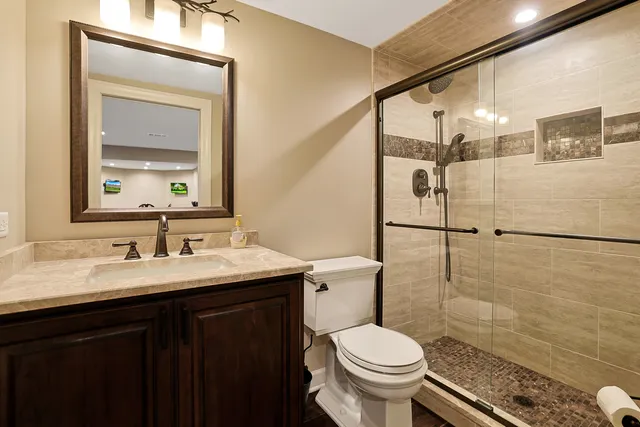 a bathroom with a granite countertop toilet sink and mirror