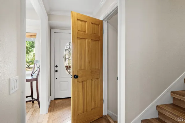 a view of a hallway with wooden floor and staircase