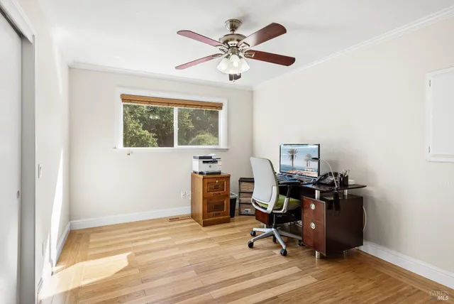 a view of a workspace with furniture and a window