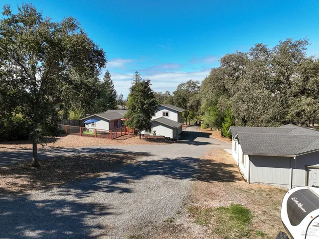 a view of a yard with car parked on road
