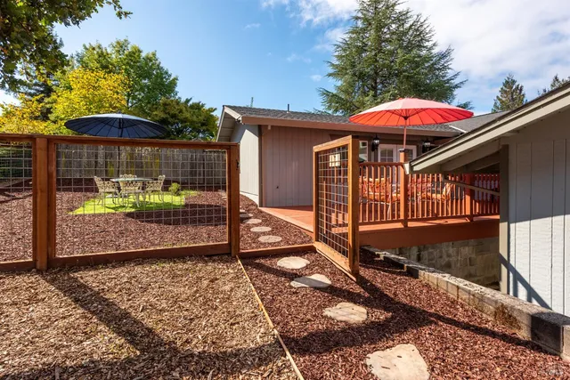 a backyard of a house with barbeque oven table and chairs