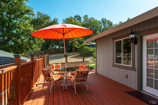 a view of a balcony with table and chairs under an umbrella