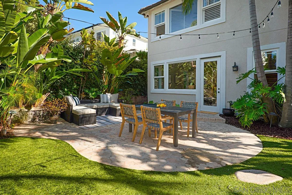 660 Cypress Hills Drive Encinitas, CA 92024 - Photo 18 of 38 a view of a patio with table and chairs potted plants and large tree