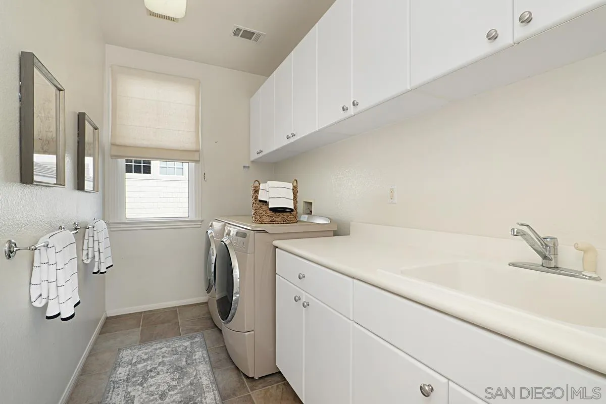 660 Cypress Hills Drive Encinitas, CA 92024 - Photo 33 of 38 a utility room with cabinets washer and dryer