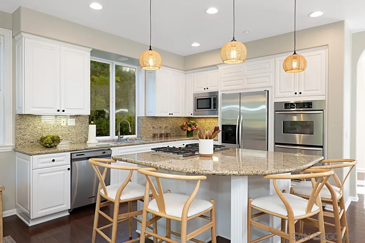 660 Cypress Hills Drive Encinitas, CA 92024 - Photo 8 of 38 a kitchen with stainless steel appliances granite countertop a sink a stove a refrigerator cabinets and chairs