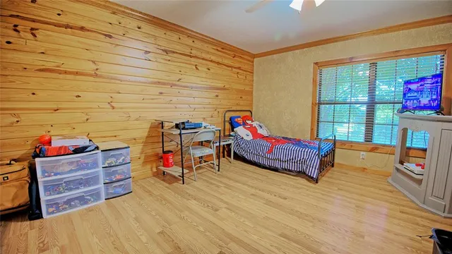 a bedroom with a bed and wooden floor