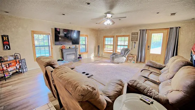 a bed room with a bed couches and a flat tv screen