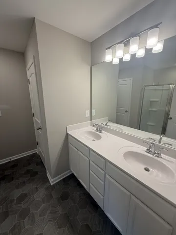 a bathroom with a double vanity sink and a mirror