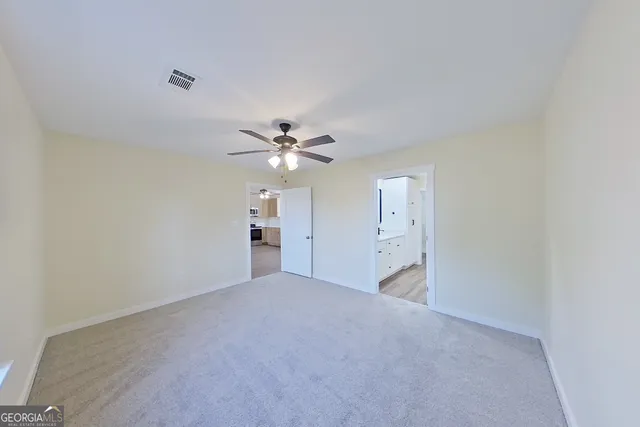 a spacious bathroom with double vanity a mirror and a shower