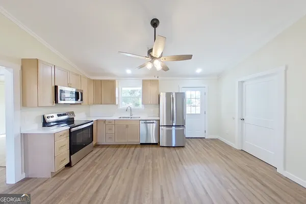 a large kitchen with a wooden floor and stainless steel appliances