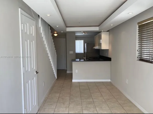 a view of a hallway to rooms and stairs