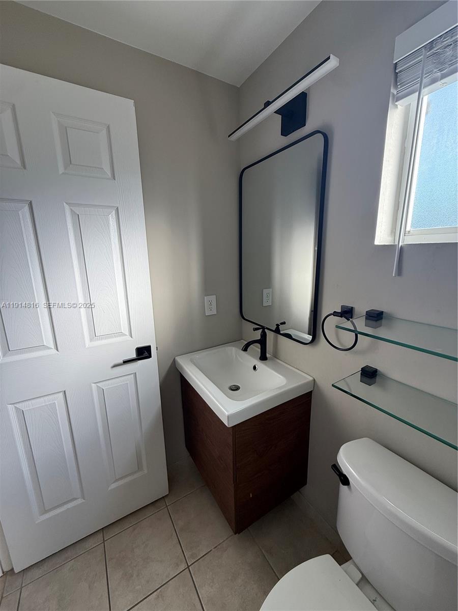 821 Southwest 2nd Street, Unit 1 Miami, FL 33130 - Photo 13 of 28 a bathroom with a toilet sink and mirror
