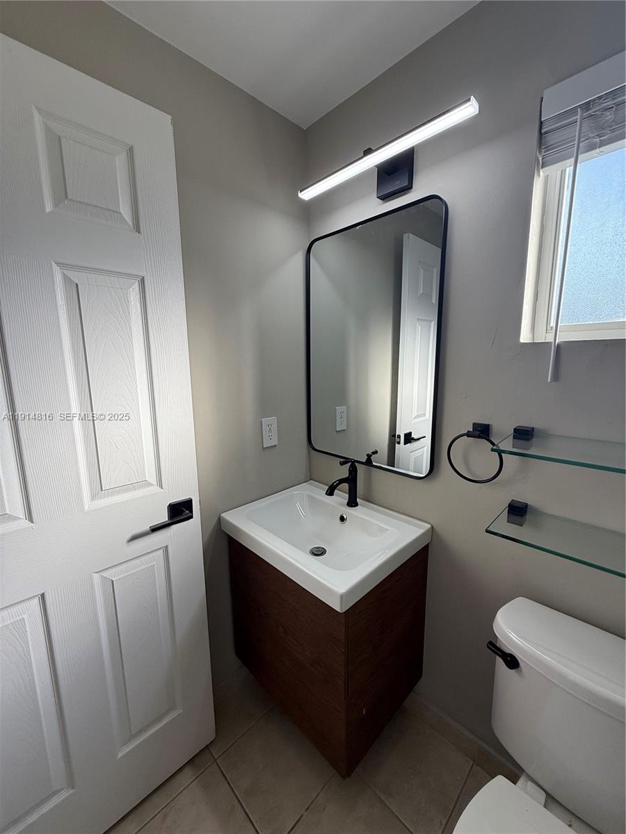 821 Southwest 2nd Street, Unit 1 Miami, FL 33130 - Photo 14 of 28 a bathroom with a toilet sink and mirror