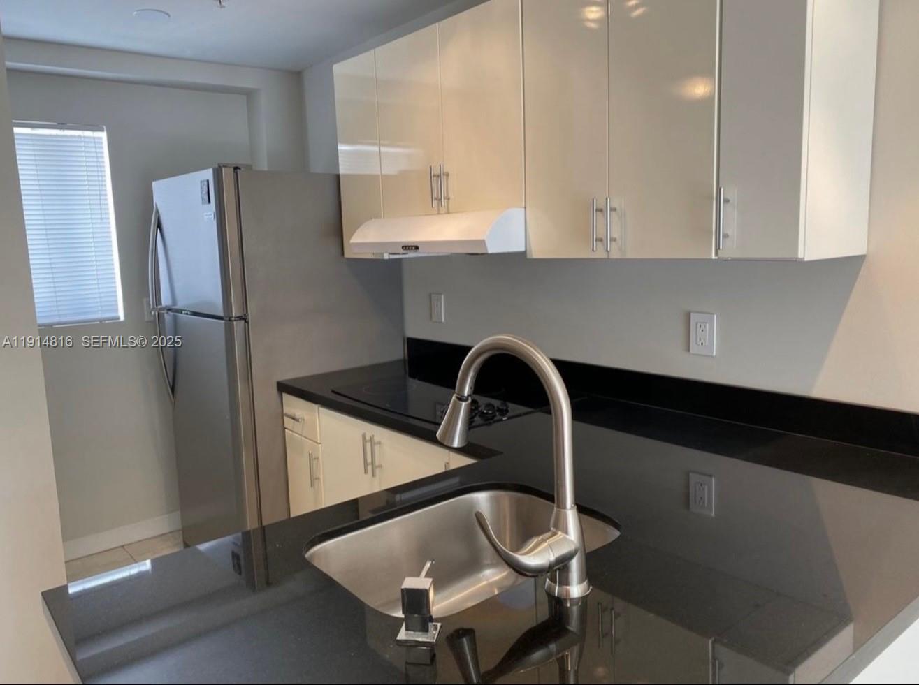 821 Southwest 2nd Street, Unit 1 Miami, FL 33130 - Photo 2 of 28 a kitchen with a refrigerator and a stove