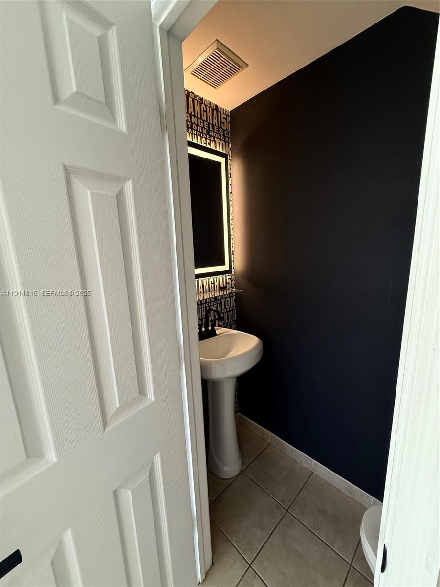 821 Southwest 2nd Street, Unit 1 Miami, FL 33130 - Photo 25 of 28 a bathroom with a sink a toilet and a mirror