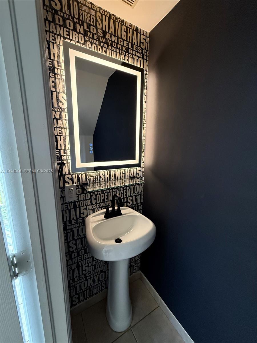 821 Southwest 2nd Street, Unit 1 Miami, FL 33130 - Photo 26 of 28 a bathroom with a sink and a mirror