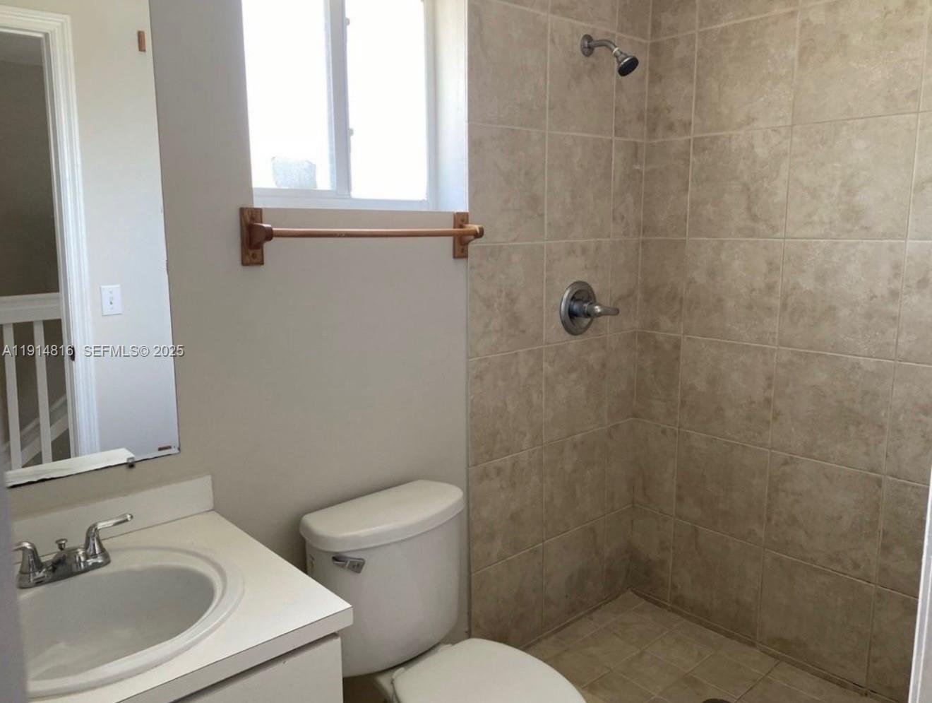 821 Southwest 2nd Street, Unit 1 Miami, FL 33130 - Photo 7 of 28 a bathroom with a sink a toilet and a mirror