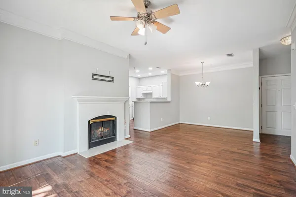 a view of empty room with a fireplace and wooden floor