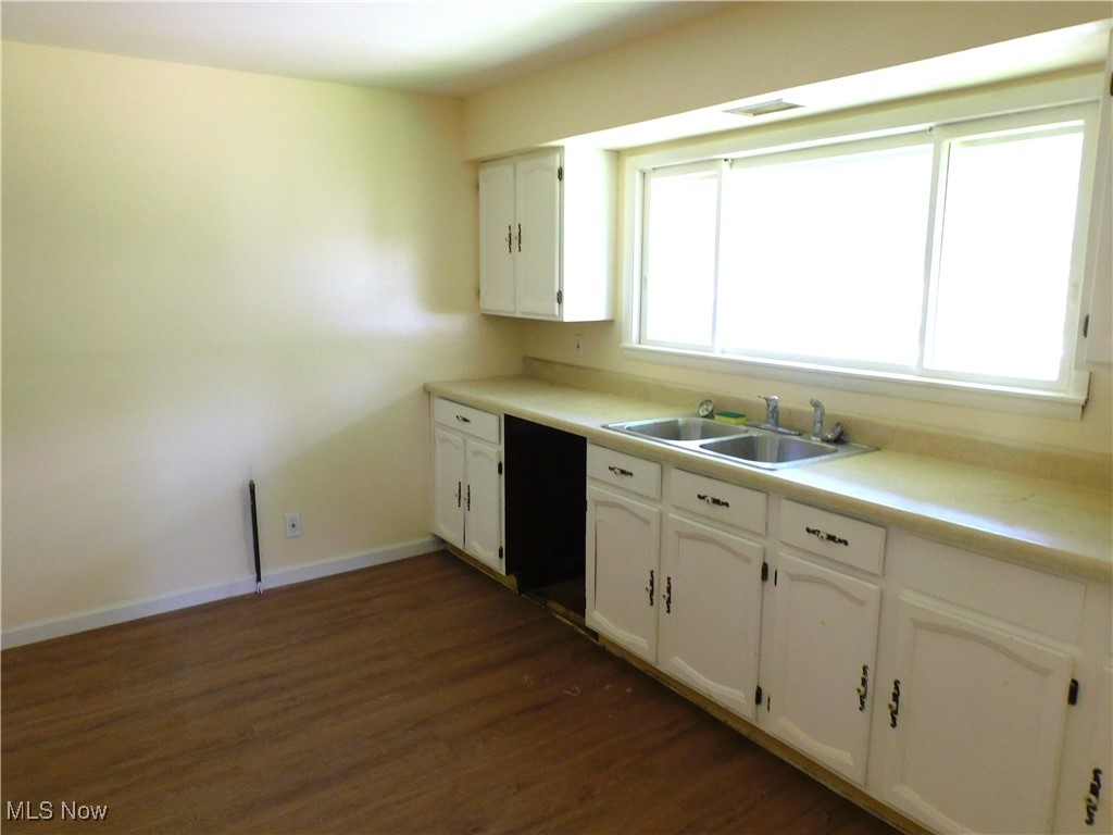 339 Johnson Plank Road Warren, OH 44481 - Photo 17 of 29 Kitchen with a sink, dark wood-style floors, white cabinets, and baseboards