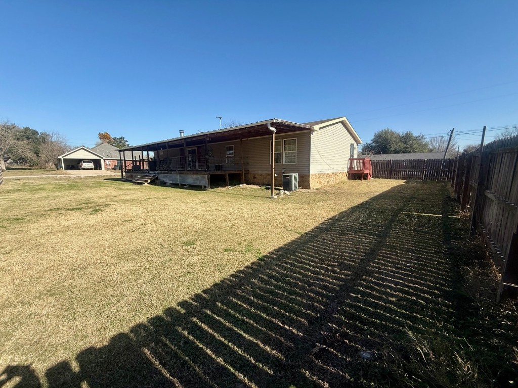 845 Caldwell Street Lexington, TX 78947 - Photo 38 of 39 Rear view of property featuring a fenced backyard and a wooden deck