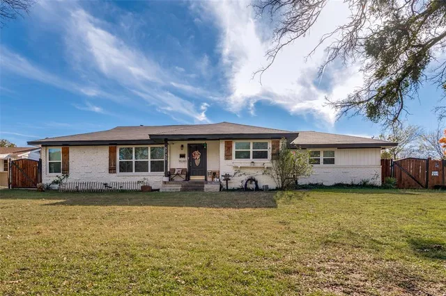 a view of a house with a big yard and large trees