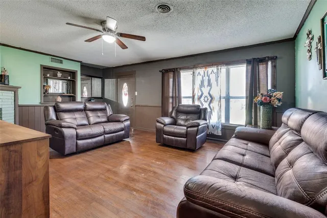 a living room with furniture ceiling fan and a large window