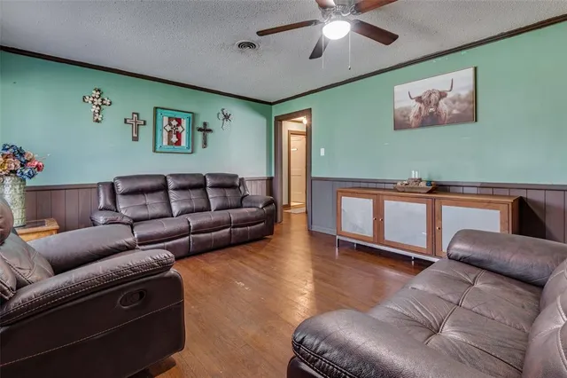 a living room with furniture and a ceiling fan