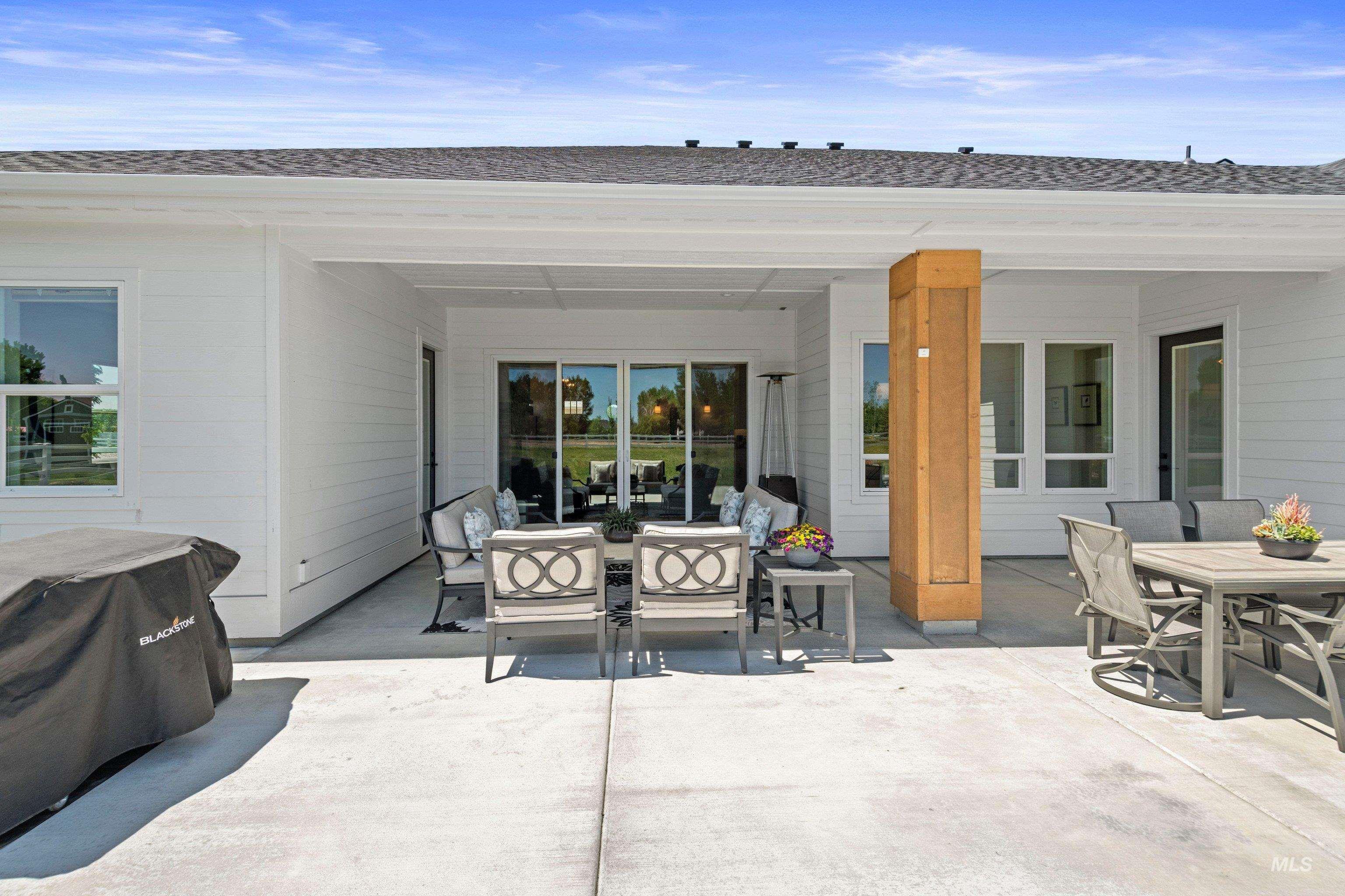24990 Belgian Way Middleton, ID 83644 - Photo 39 of 50 Expansive concrete patio with a covered outdoor living area featuring a wood-wrapped structural column