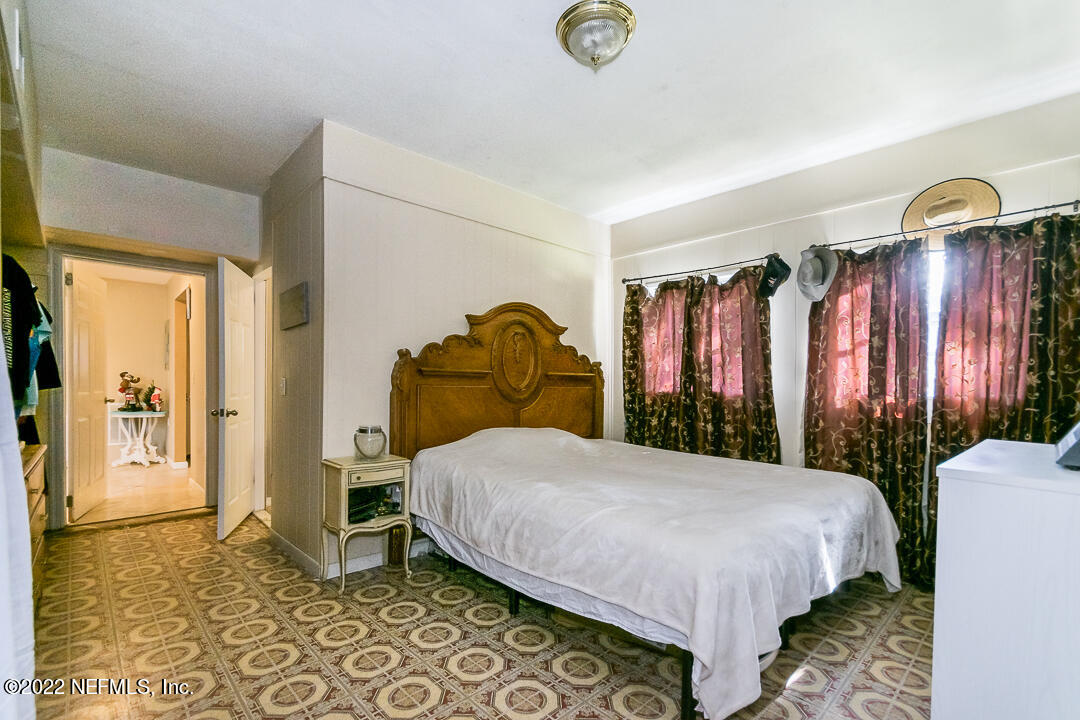 635 Jasmine Street Atlantic Beach, FL 32233 - Photo 11 of 20 a bedroom with a bed lamp and a large window