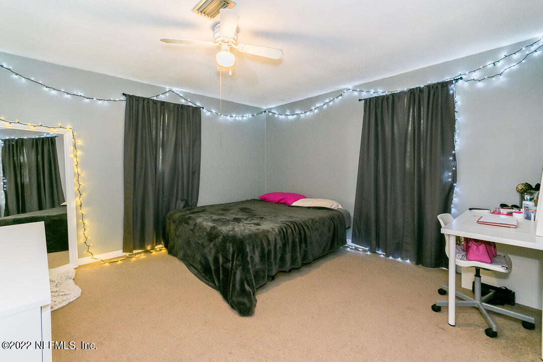 635 Jasmine Street Atlantic Beach, FL 32233 - Photo 15 of 20 a bedroom with a bed and a chandelier