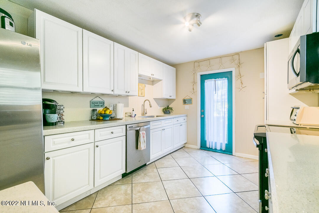 635 Jasmine Street Atlantic Beach, FL 32233 - Photo 10 of 20 a kitchen with a stove a sink and a refrigerator