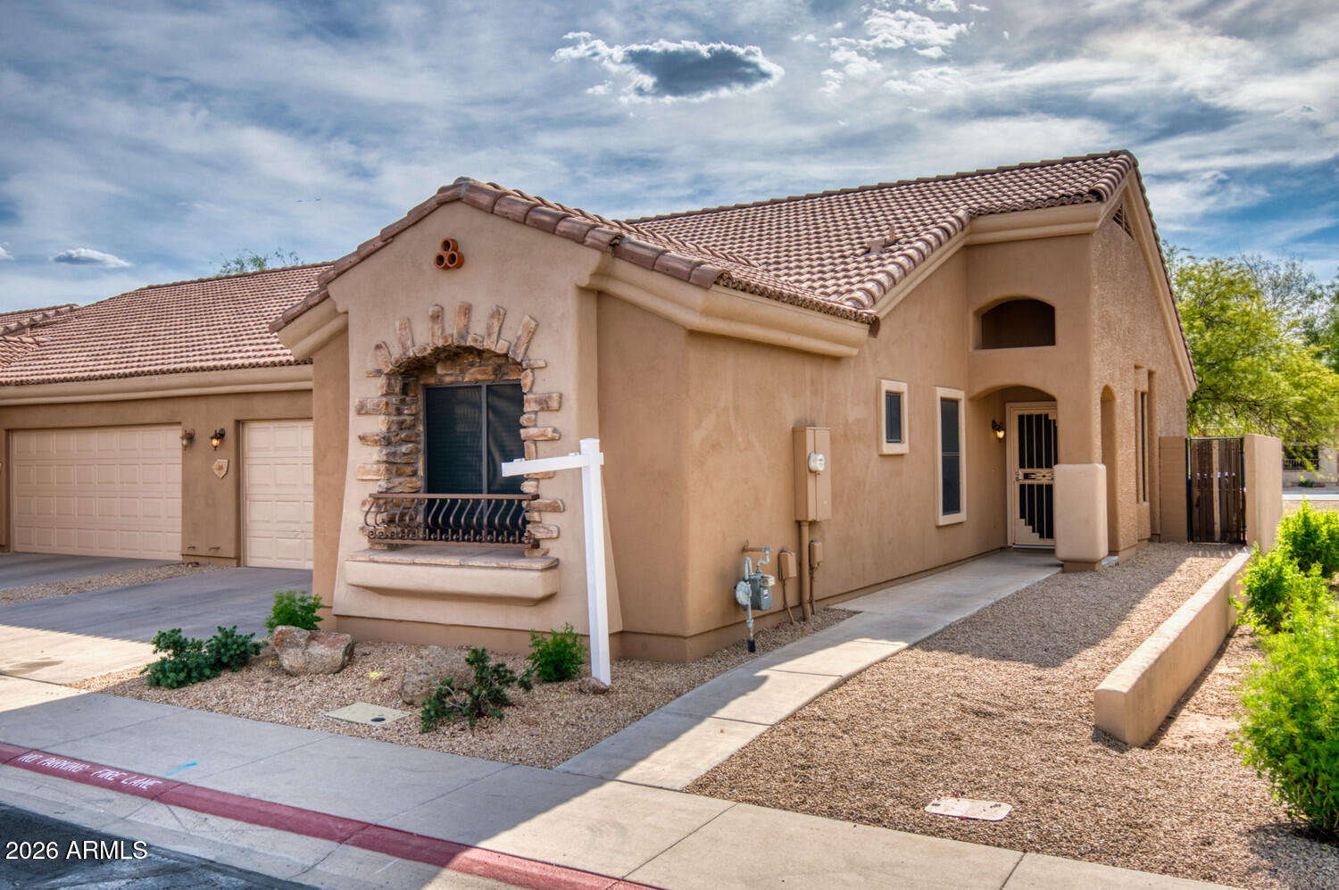 2565 South Signal Butte Road, Unit 46 Mesa, AZ 85209 - Photo 11 of 44 a view of a white house with many windows and plants