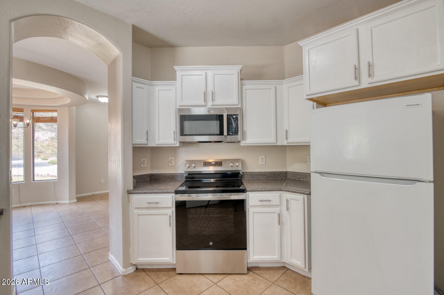 2565 South Signal Butte Road, Unit 46 Mesa, AZ 85209 - Photo 34 of 44 a kitchen with white cabinets and stainless steel appliances