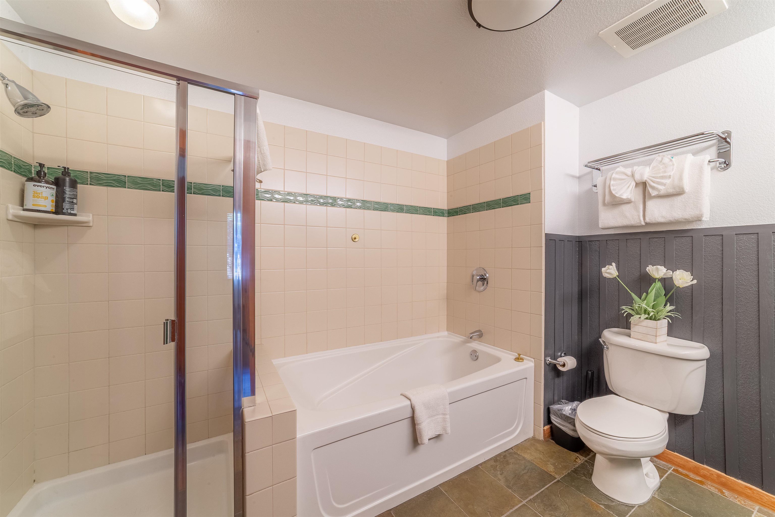 6201 Minaret Road, Unit 2221 Mammoth Lakes, CA 93546 - Photo 35 of 44 Bathroom featuring a walk-in shower with glass enclosure, a white soaking tub, and a toilet