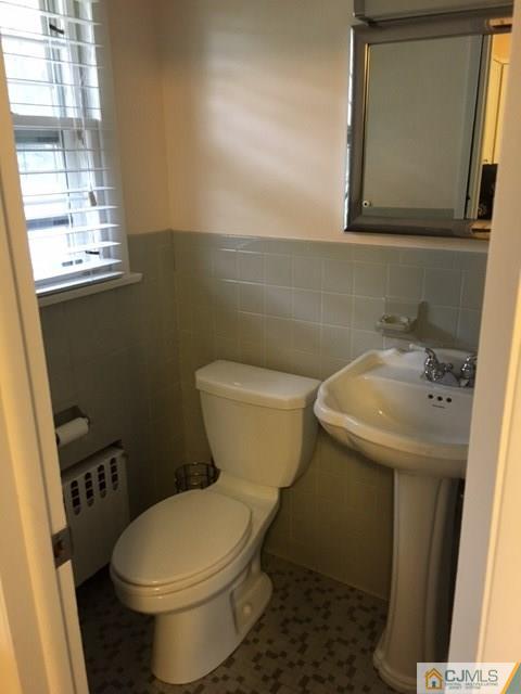 88 Dellwood Road Edison, NJ 08820 - Photo 12 of 16 a white toilet sitting next to a bathroom sink