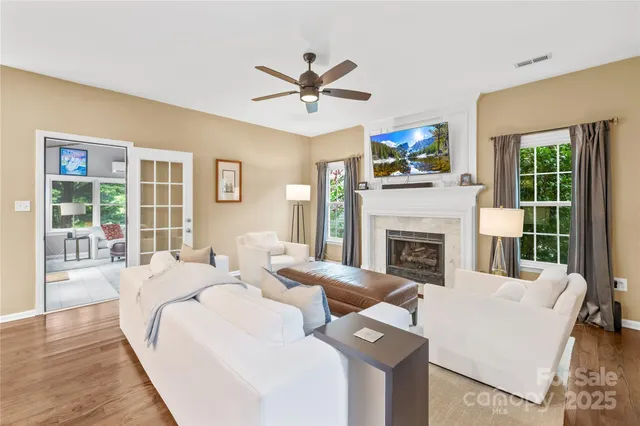 a living room with fireplace furniture and a large window