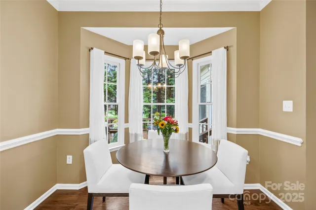 a dining room with furniture a chandelier and window