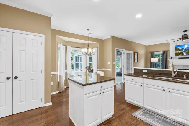 a kitchen with white cabinets and sink