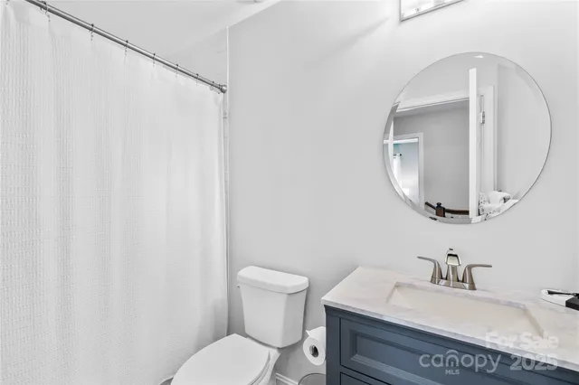 a bathroom with a sink vanity mirror and toilet
