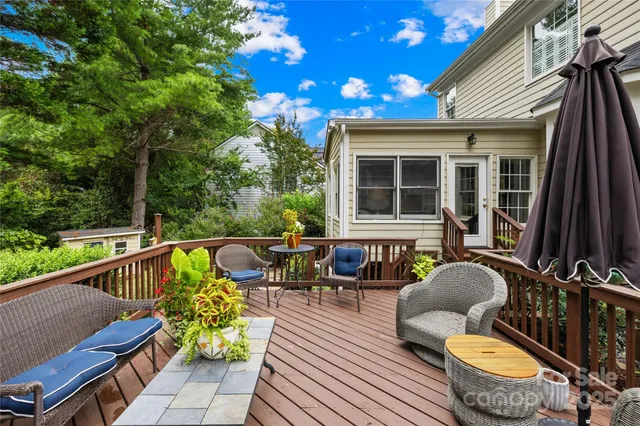 a balcony with wooden floor and outdoor seating