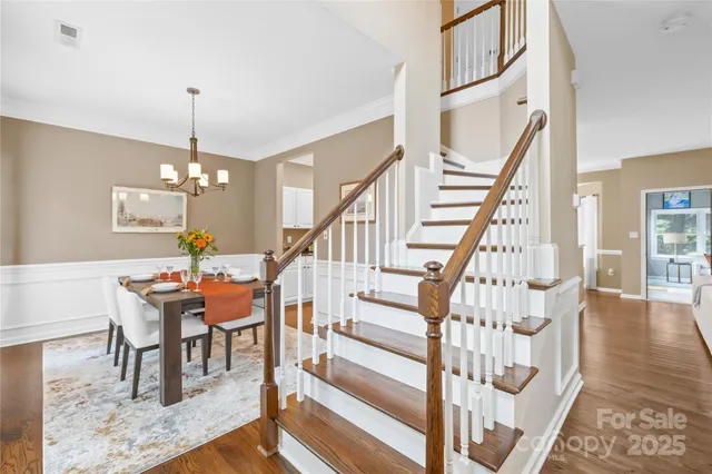 a view of a dining room with furniture wooden floor and chandelier