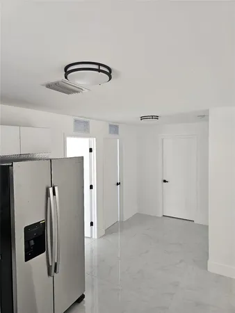 a view of a kitchen with a refrigerator and microwave