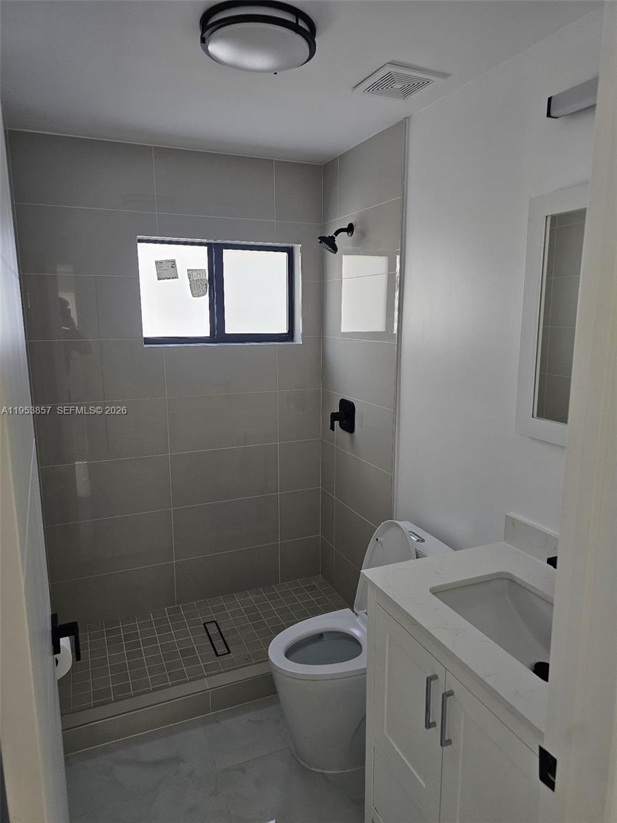 11997 Southwest 218th Street Miami, FL 33170 - Photo 12 of 16 a bathroom with a granite countertop toilet a sink and shower