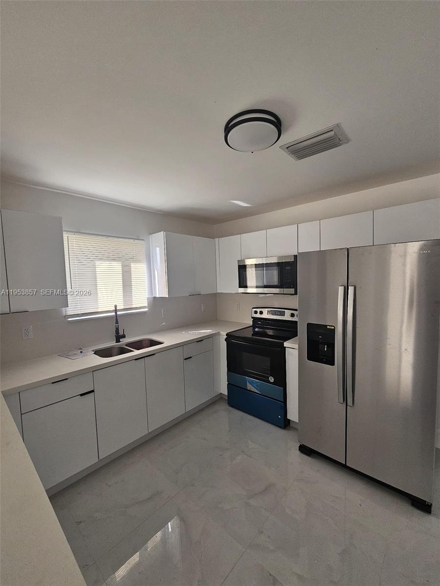 11997 Southwest 218th Street Miami, FL 33170 - Photo 2 of 16 a large kitchen with cabinets and stainless steel appliances