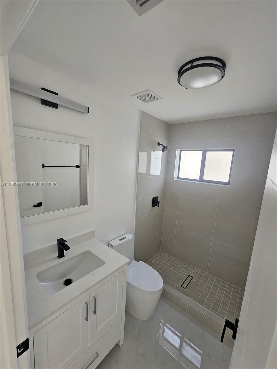 11997 Southwest 218th Street Miami, FL 33170 - Photo 5 of 16 a bathroom with a sink a toilet and a mirror