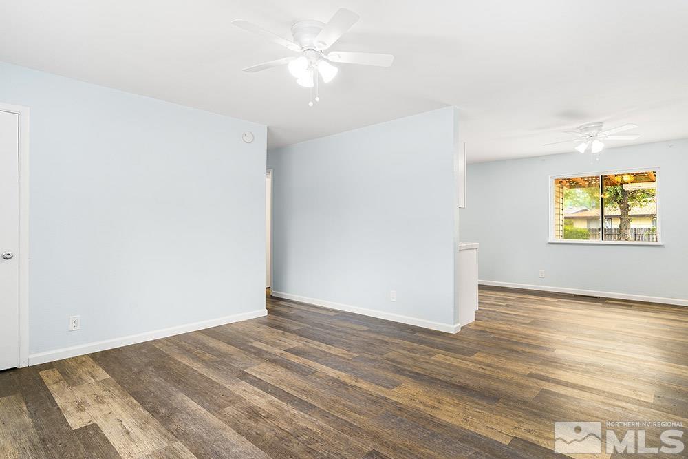 3408 Rauscher Drive Reno, NV 89503 - Photo 4 of 16 an empty room with wooden floor chandelier fan and windows