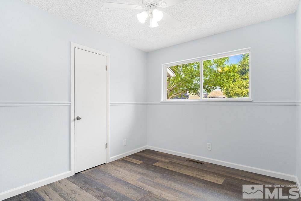 3408 Rauscher Drive Reno, NV 89503 - Photo 10 of 16 an empty room with wooden floor fan and windows