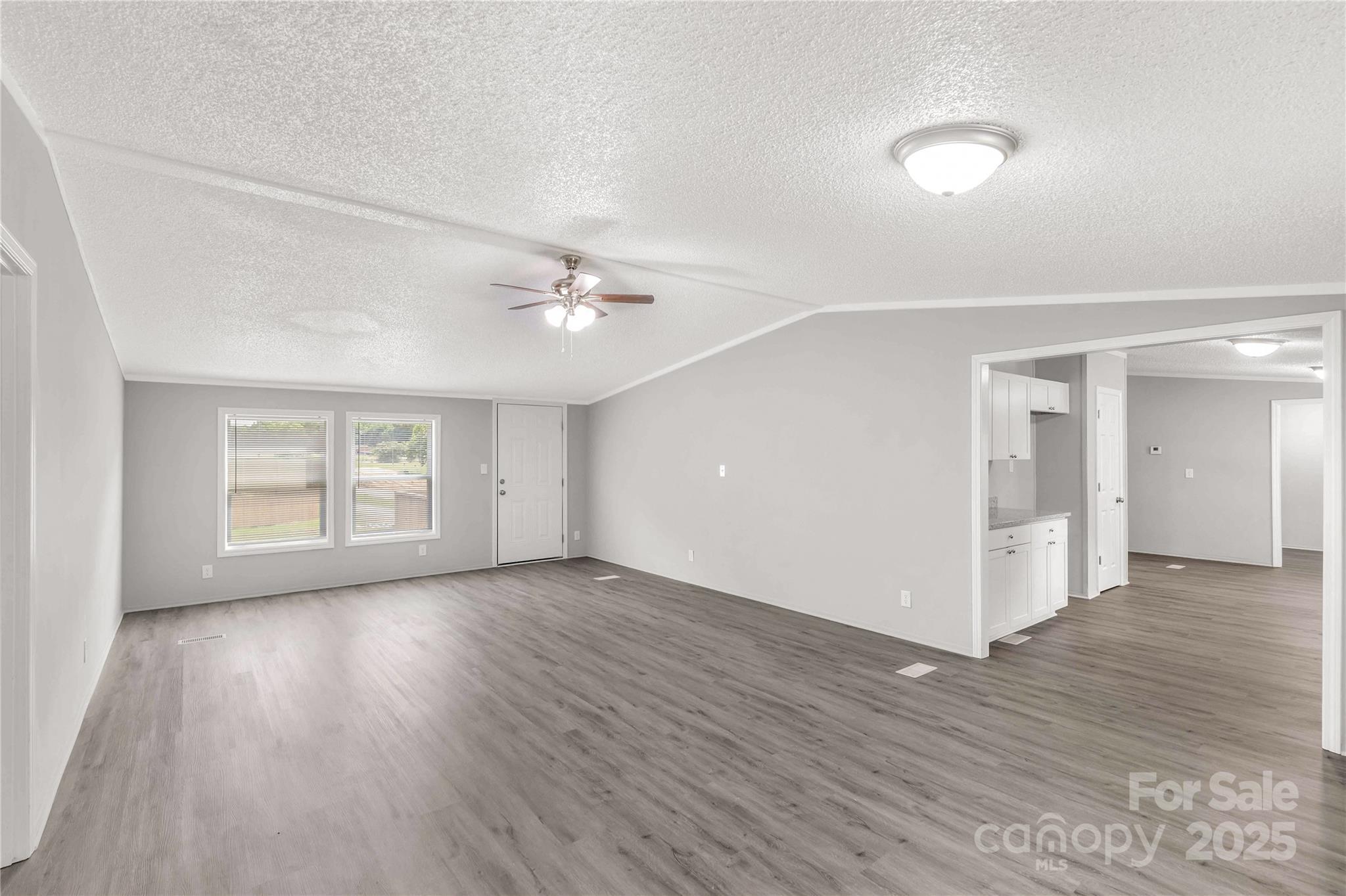 2007 Sugar Hill Road York, SC 29745 - Photo 9 of 36 an empty room with wooden floor chandelier and windows